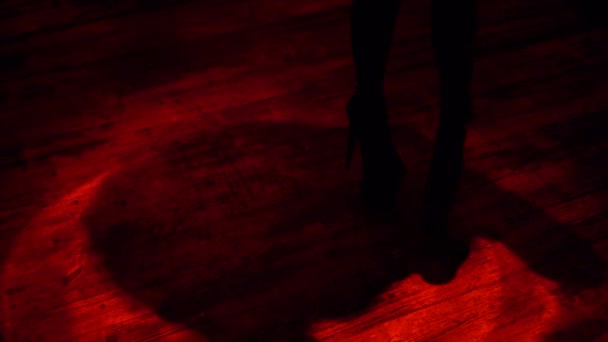 Sexy woman legs in high heels dancing in red light beam inside of strip bar night club - Footage, Video