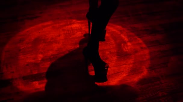Sexy mujer piernas en tacones altos bailando en haz de luz roja dentro de la barra de striptease club nocturno
 - Imágenes, Vídeo