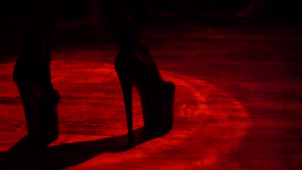 Sexy femmes jambes en talons hauts dansant en faisceau de lumière rouge à l'intérieur de strip-tease bar night club
 - Séquence, vidéo