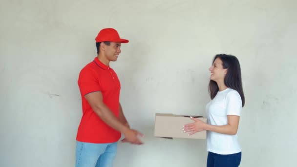 Uśmiechnięty mężczyzna dostawy dostarczania paczek do kobiety - Materiał filmowy, wideo