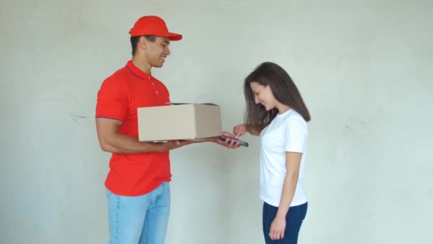 Repartidor sonriente entregando el paquete a una mujer
 - Imágenes, Vídeo