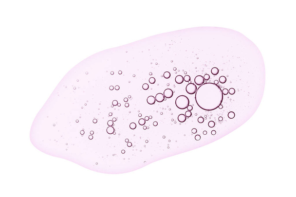 Textura de suero facial. Gel líquido transparente rosa con manchas de burbujas aisladas sobre fondo blanco
. - Foto, imagen