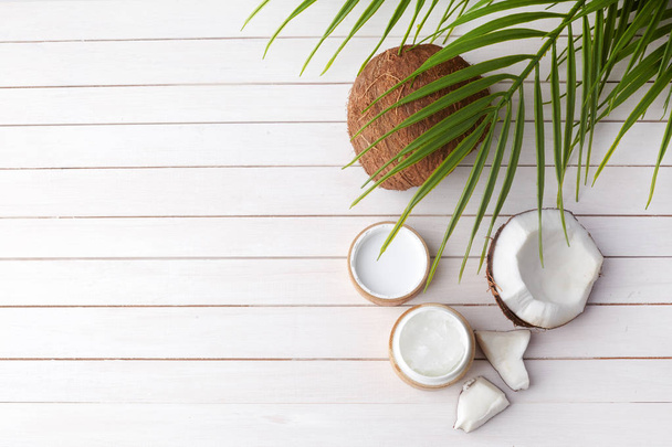 Coconut oil with fresh cocnut, natural cosmetic, flat lay image on wooden background - Foto, immagini
