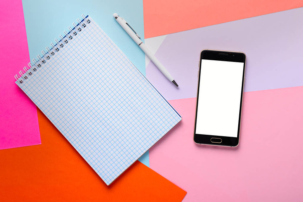 clean notepad with pen and smartphone with white screen for layout - 写真・画像
