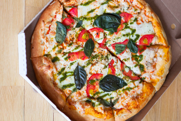 Pizza italiana gostosa quente com legumes em caixa no backgro de madeira
 - Foto, Imagem