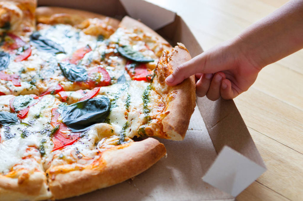 Perhepäivällinen. Kädet ottavat pizzaviipaleita laatikolla. Ystävä
 - Valokuva, kuva