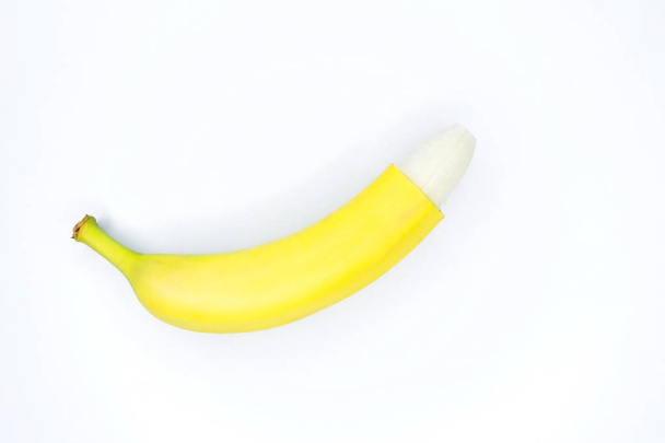 Vliegende banaan. Gesneden gele banaan geïsoleerd op witte achtergrond met uitknippad. Levity fruit drijvend in de lucht. Creatief concept met vliegende vruchten. - Foto, afbeelding
