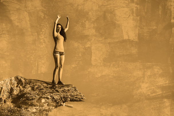 Acrofobia mulher alta fica no topo de uma borda penhasco de rocha e é
 - Foto, Imagem