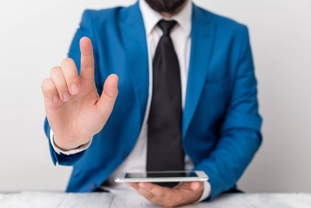 Businessman with pointing finger in front of him. Businessman holds lap top in hand and points with his finger. - Photo, Image