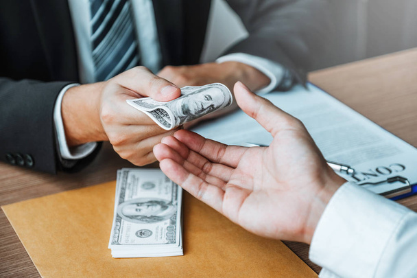 Корупція та хабарництво, бізнесмен дає доларові купюри
 - Фото, зображення