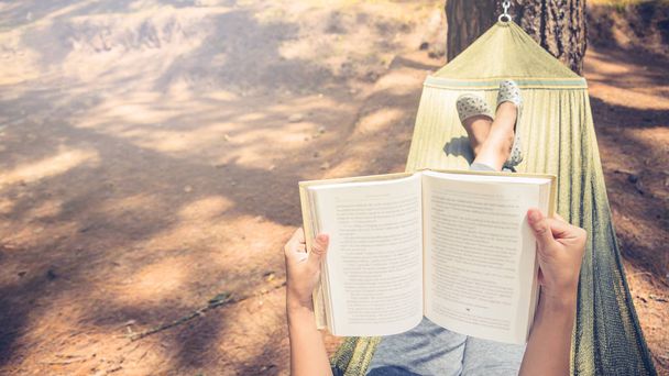 Frauen schlafen beim Lesen. in der Hängematte. in der natürlichen Atmosphäre des Parks - Foto, Bild
