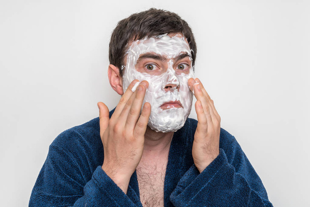 Funny man with natural white cream mask on his face - 写真・画像