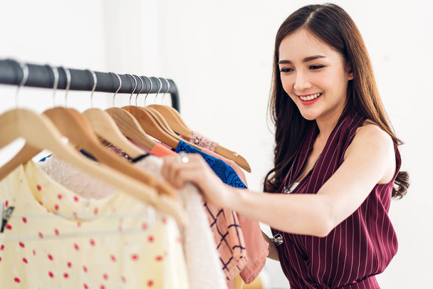 Belle jeune asiatique femme shopping et choisir des vêtements dans un st
 - Photo, image
