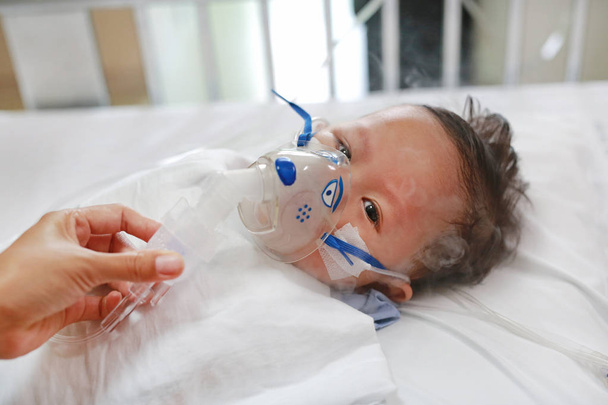 Baby has asthma and need nebulizations, Sick boy inhalation therapy by the mask of inhaler. Baby boy has a nasal congestion. Baby boy making inhalation with nebulizer. - Foto, afbeelding