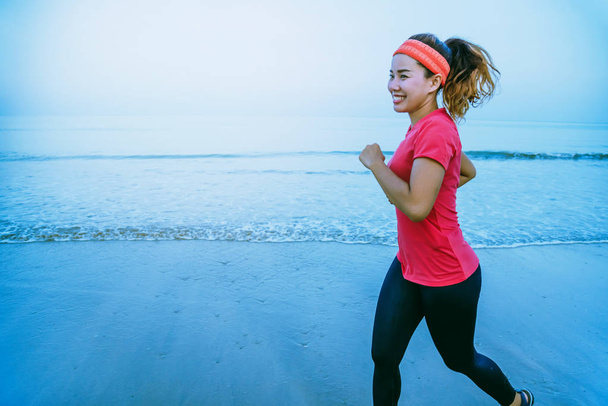 Žena běhání cvičení na pláži po ránu. Relaxujte s procházkou po moři. v létě - Fotografie, Obrázek