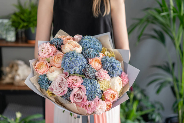 Beau bouquet de fleurs mixtes à la main de la femme. Concept de boutique florale. Beau bouquet frais. Livraison de fleurs. Couleur bleue et rose
 - Photo, image
