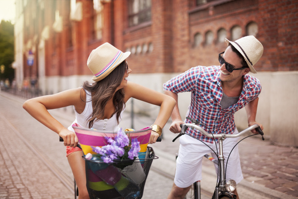 Heureux couple poursuivant à vélo dans la rue
 - Photo, image