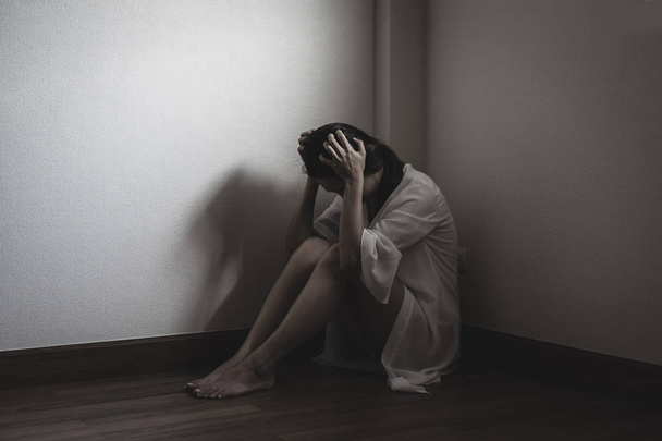 Femme déprimée et stressée assise sur le sol seule tête dedans
  - Photo, image