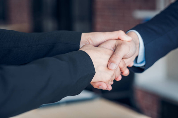 Close up two handshake between businesswoman and businessman at  - Foto, imagen