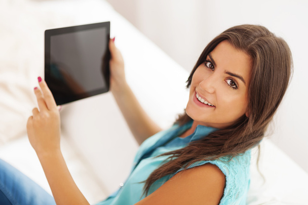 Mujer bastante joven usando tableta digital en casa
 - Foto, imagen