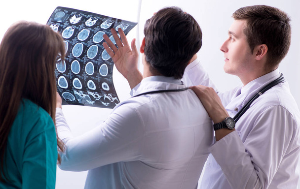 Три врача обсуждают результаты сканирования рентгеновского изображения - Фото, изображение