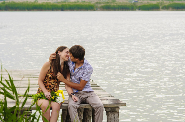 Young girl and the young man on the dock by the river - Foto, Imagen