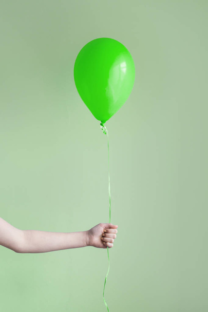 ruka držící jeden zelený balónek - Fotografie, Obrázek