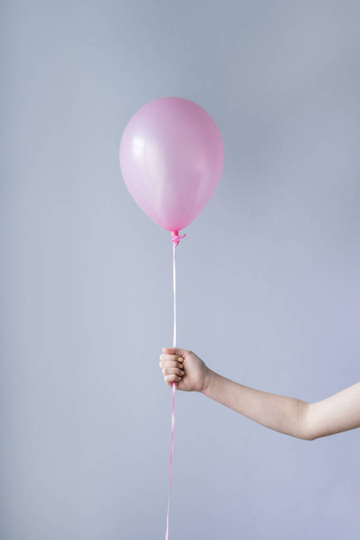 ruka držící jeden růžový balónek - Fotografie, Obrázek