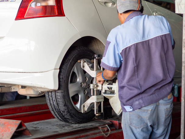 Mechanicus wisselende auto wiel in auto reparatiewerkplaats  - Foto, afbeelding