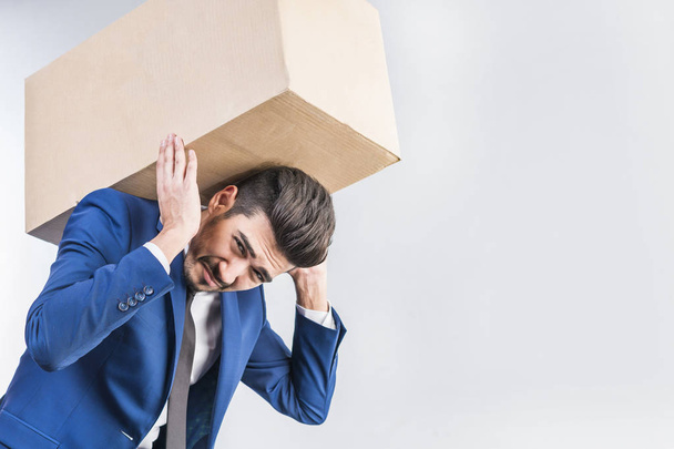 Attractive  man  carries a cardboard box on his back. - 写真・画像