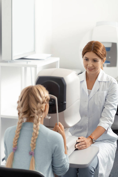 Blonde-haired girl visiting eye doctor in private clinic - Photo, Image