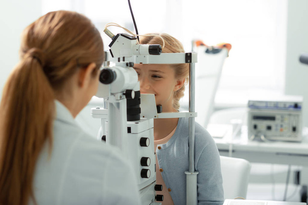 Profesyonel göz doktoru ziyaret ederken gülümseyen sevimli genç kız - Fotoğraf, Görsel