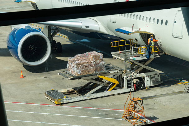Raktér betöltése poggyász és rakomány a repülőgép kezelési műveletek repülőtéren, utazás és szállítás koncepció - Fotó, kép