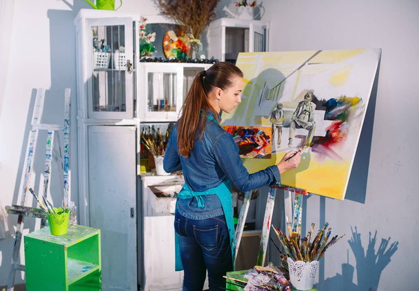 Beautiful Girl in a Painting Studio draws a picture. - Φωτογραφία, εικόνα