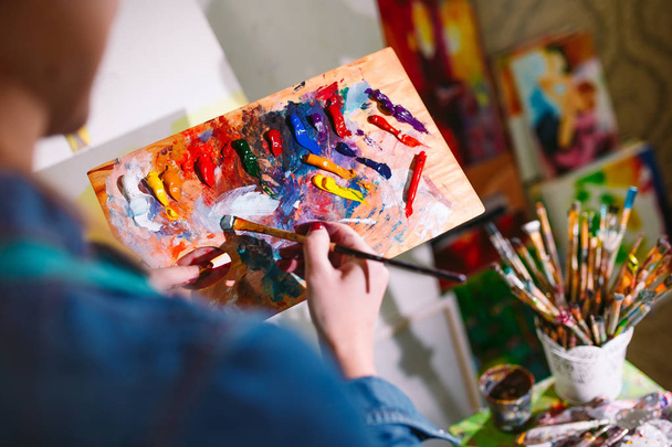 Beautiful Girl in a Painting Studio draws a picture. - 写真・画像