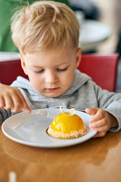 Niño comiendo postre en la cafetería
 - Foto, imagen
