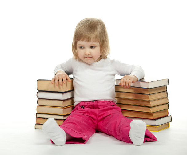 Little girl sitting among books - Foto, Imagen