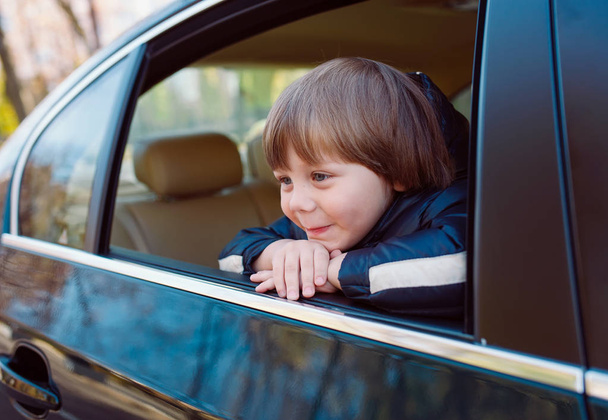Baby boy in the black car with beige interior. - Foto, Imagem