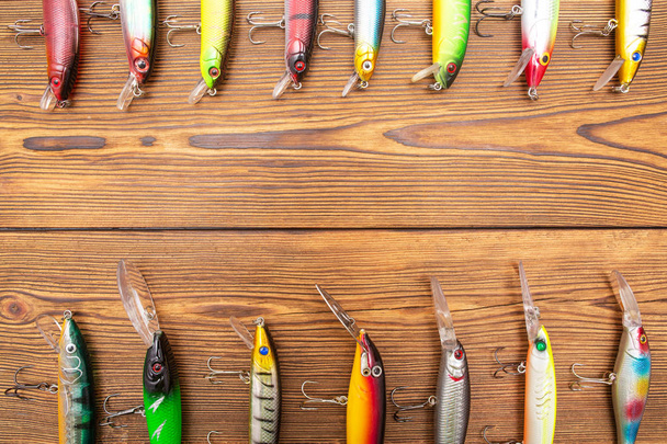 Fishing tackle and wobblers on wooden background. Concept of selling fishing gear. Copy space - Photo, image