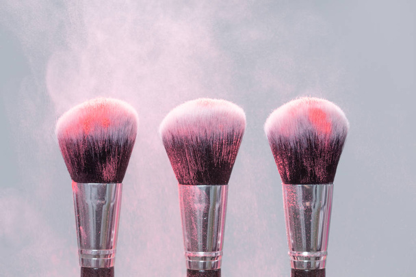 Μακιγιάζ, ομορφιά, ορυκτό καλλυντικό έννοια-πινέλο με ροζ σκόνη στο φως φόντο - Φωτογραφία, εικόνα