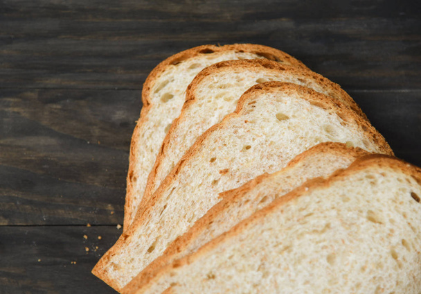 Ψωμί σε φέτες, κοντά στην κορυφή-ψωμί ολικής άλεσης κομμένο σε ξύλινο - Φωτογραφία, εικόνα