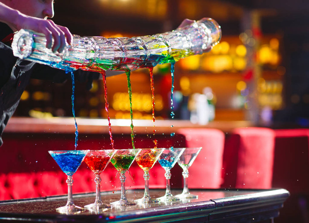 Barman show. Bartender pours alcoholic colorful cocktails. - Valokuva, kuva