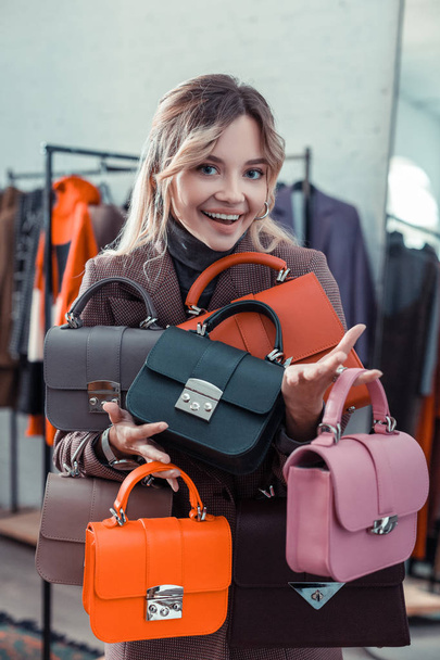 Businesswoman owning fashion boutique holding little hand bags - Φωτογραφία, εικόνα