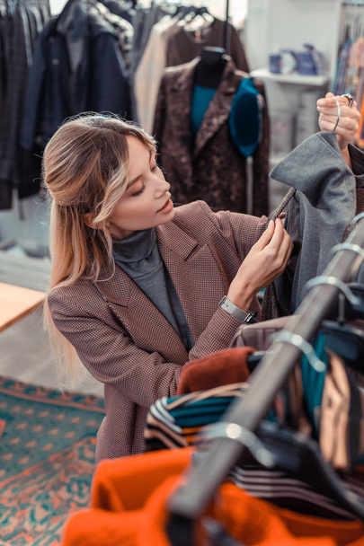 Mujer mirando la tela mientras elige ropa nueva
 - Foto, imagen