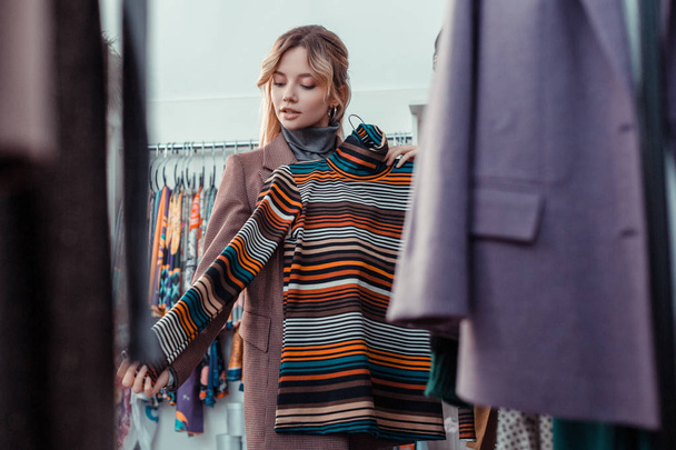 Blonde young businesswoman buying new autumn clothes - Valokuva, kuva
