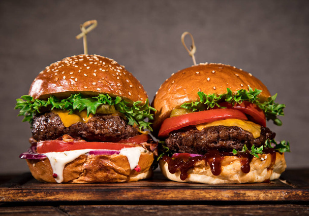 Tasty burgers on wooden table. - Foto, Bild