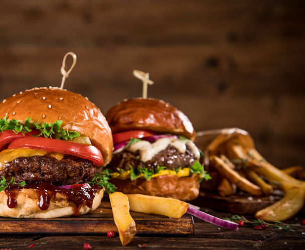 Tasty burgers on wooden table. - Fotoğraf, Görsel