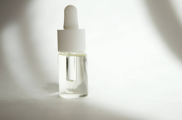 Cosmetic or medical glass bottle with pipette on white background. Skin care concept. Natural hard light, deep shadows. - Image - Φωτογραφία, εικόνα