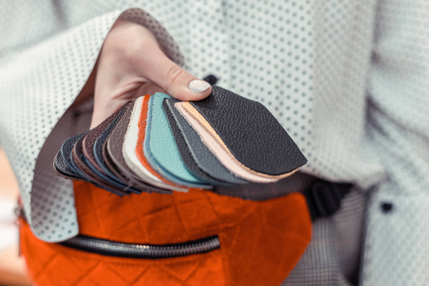 Diseñador de moda sosteniendo pequeñas piezas de cuero colorido
 - Foto, Imagen