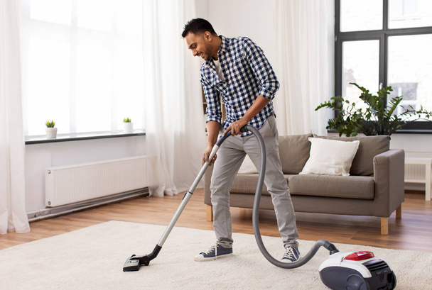 indian man with vacuum cleaner at home - Foto, immagini